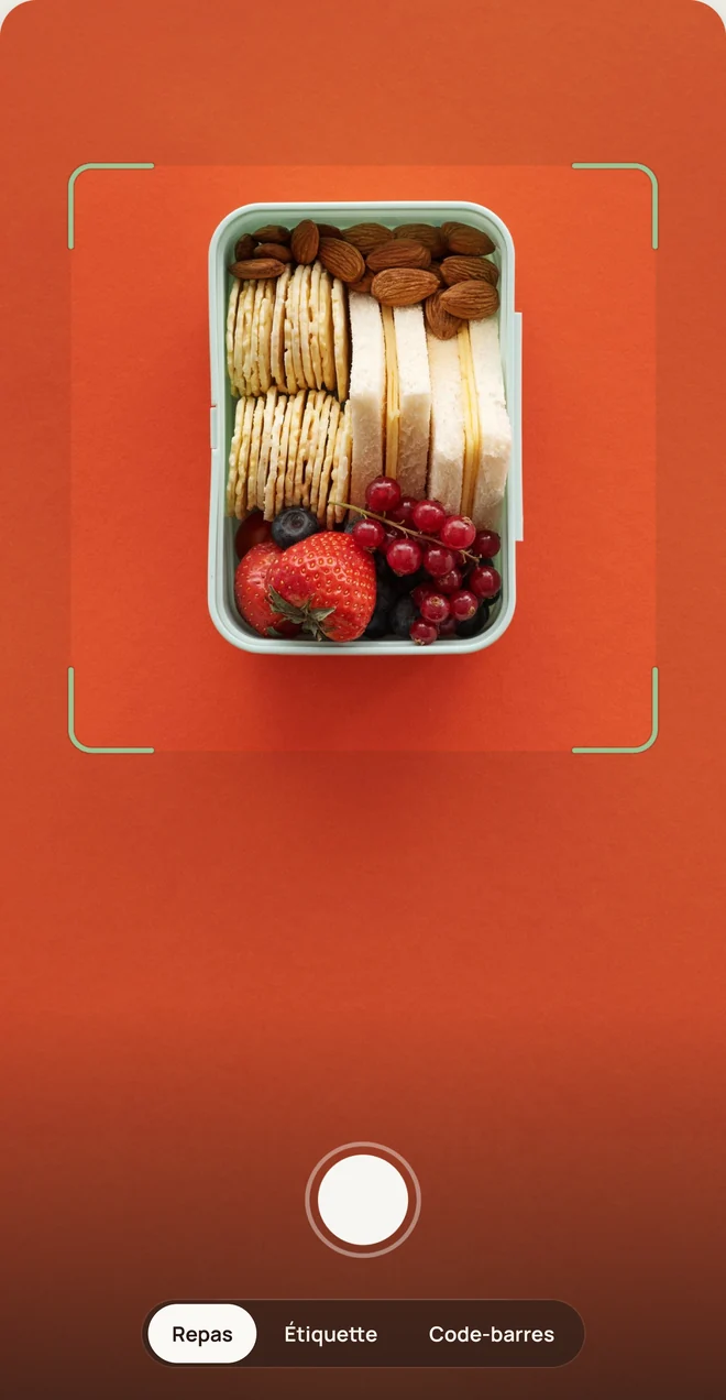 L&rsquo;appareil photo pointé sur une lunchbox avec des sandwichs, des crackers, des amandes et des fruits.
